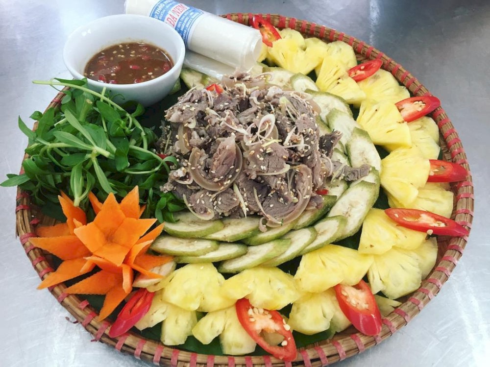 Món nem dê núi Ninh Bình tuyệt nhất khi ăn kèm với lá sung, lá ổi, khế, lá mơ, chuối xanh, rau thơm và chấm kèm tương gừng